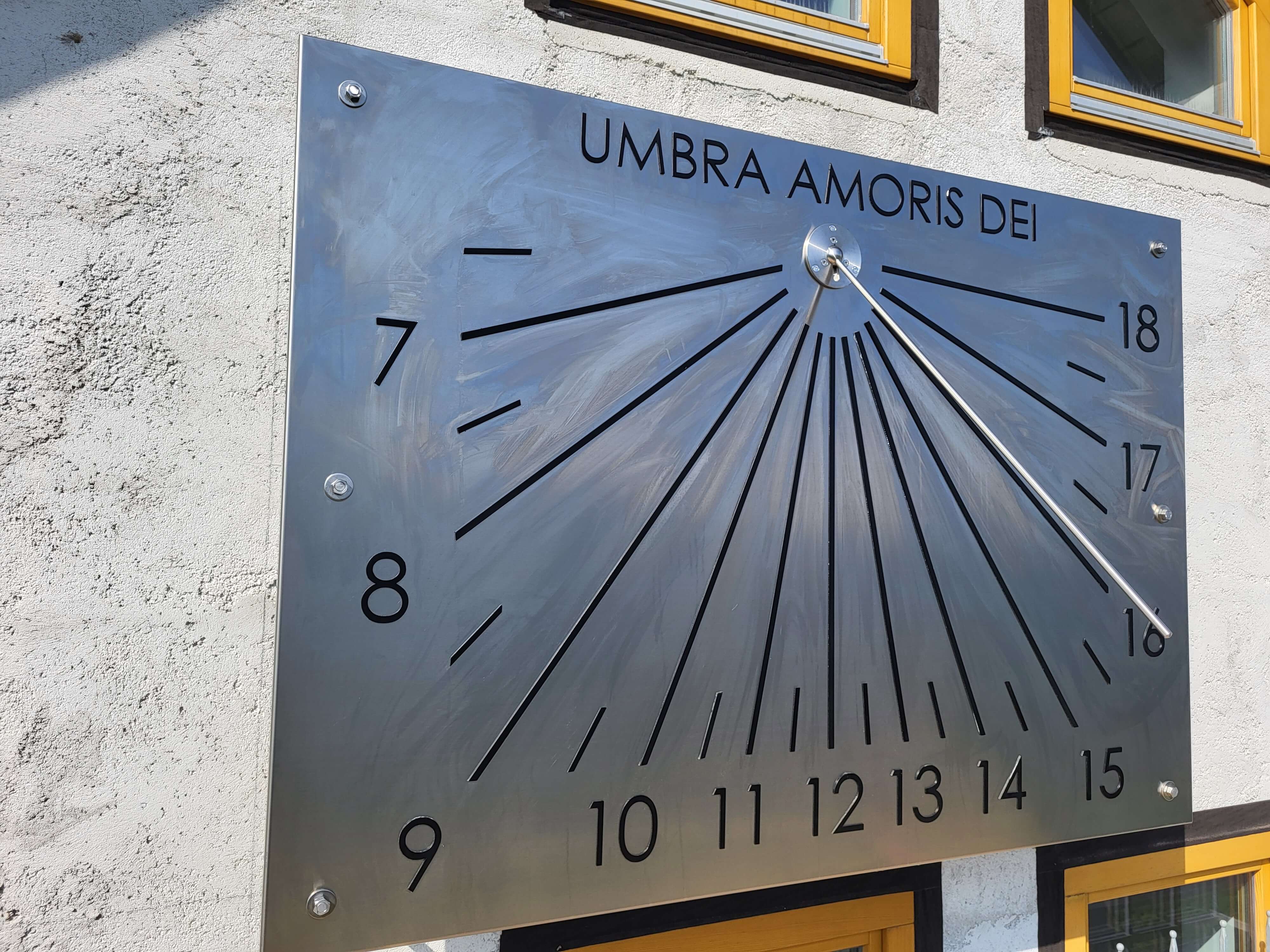 Vertikalna sončna ura iz nerjavnega jekla na steni objekta